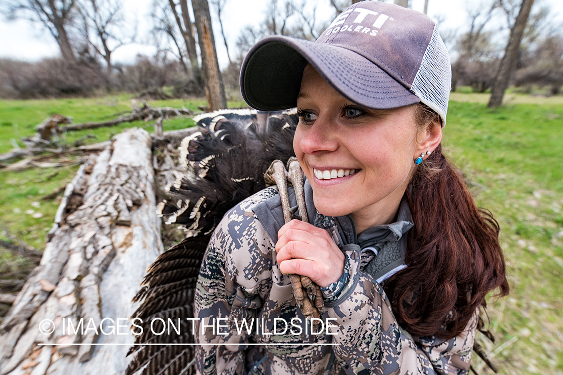 Woman hunter with bagged turkey.