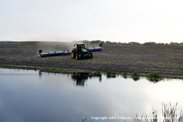 Farmer working field near wetlands