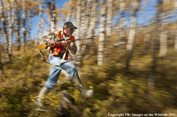 Hunter running through forest. 