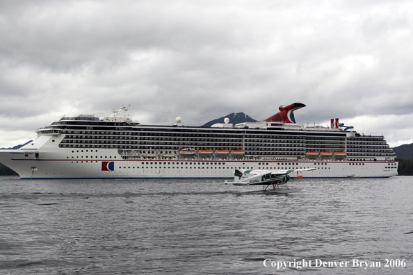 Float plane taking off in front of a cruise ship.  (Alaska)