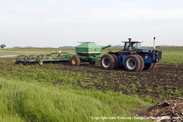 Farmer working field near wetlands