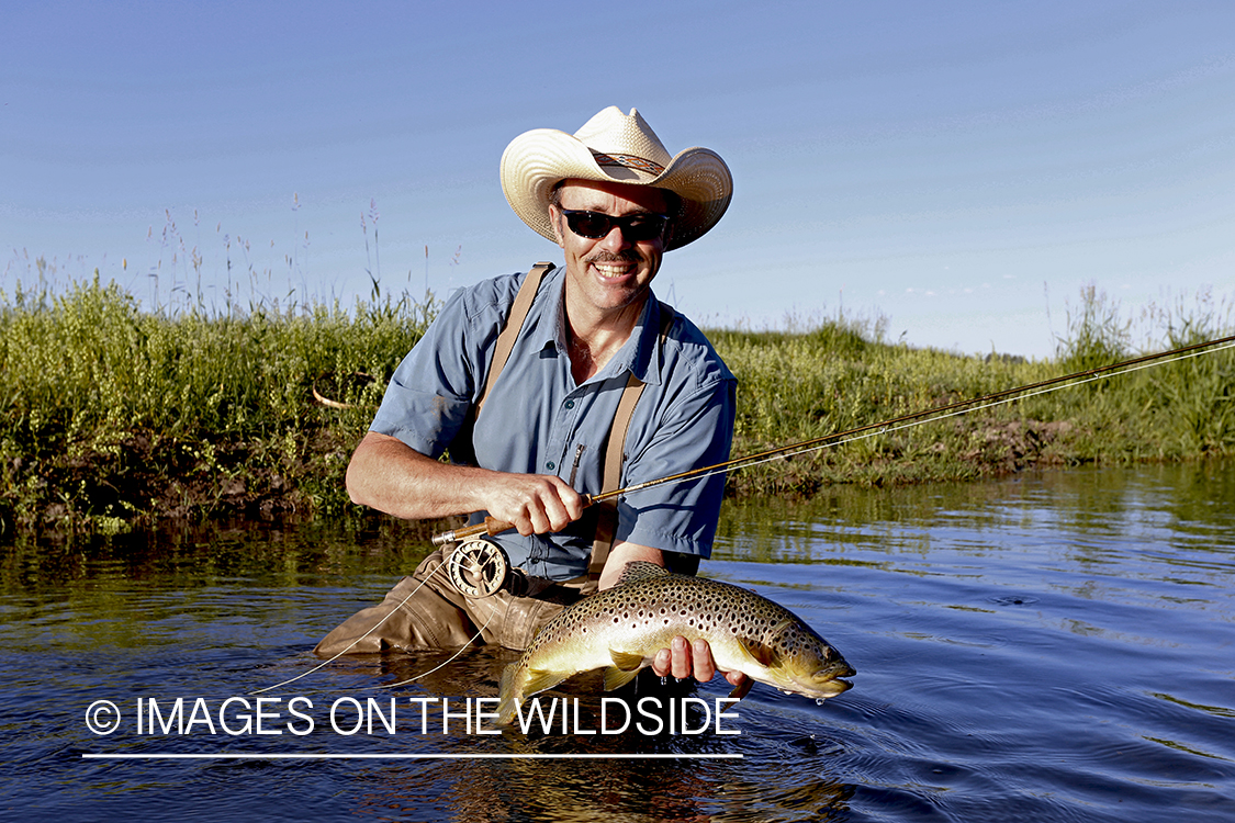 Flyfisherman with brown trout. 