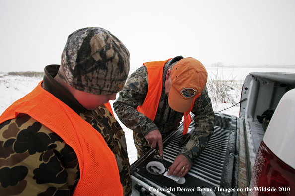 Father helps son get his white-tail deer tag ready