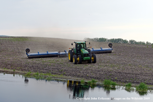 Farmer working field near wetlands