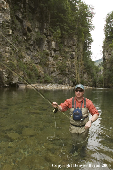 Flyfisherman casting on river.