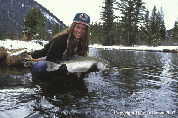 Woman flyfisher with rainbow trout.