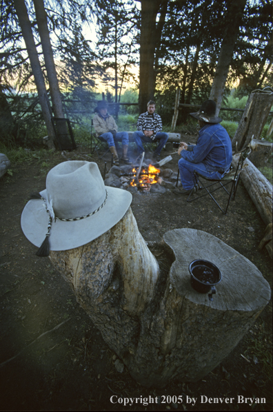 Cowboys sitting around campfire.