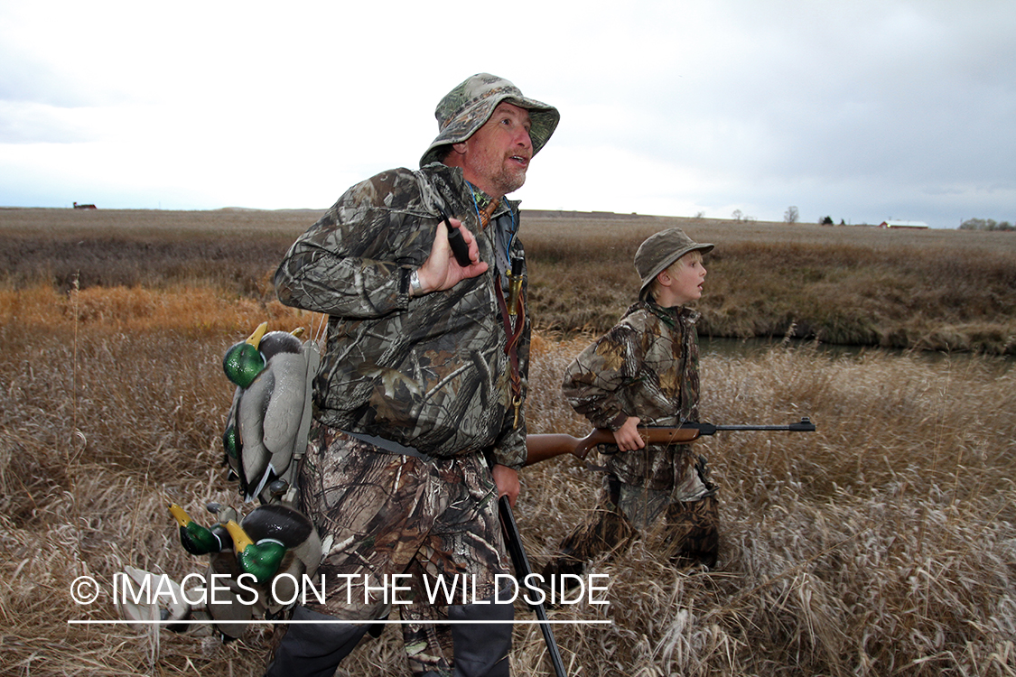 Father and son waterfowl hunters with bagged waterfowl.