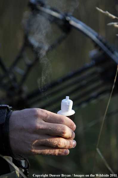 Bow hunter using wind smoke (powder) to test wind. 