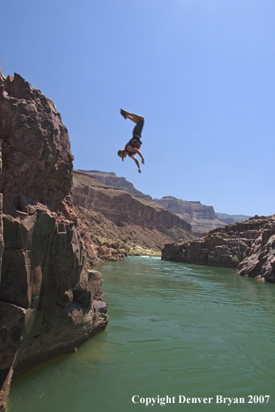 Swimmers jumping into waterfall/feeder stream of the Colorado River.  Grand Canyon.