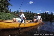 Father and son fishing from cedar canoe.