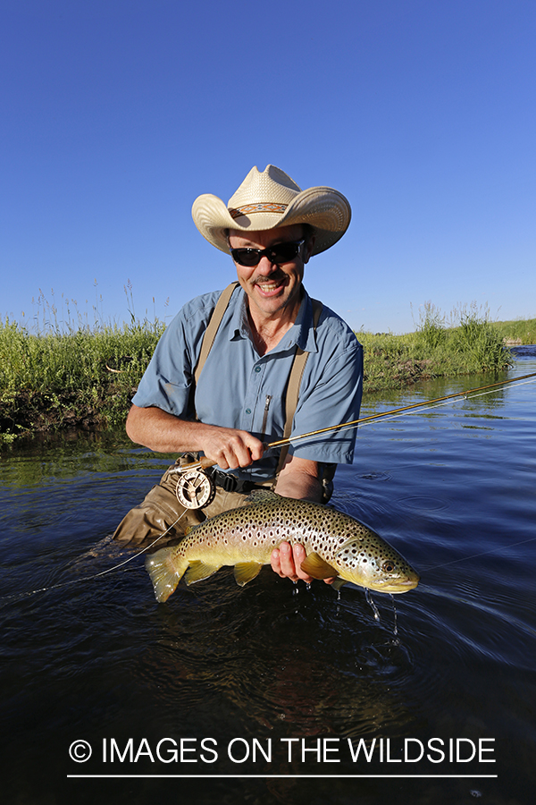 Flyfisherman with brown trout. 