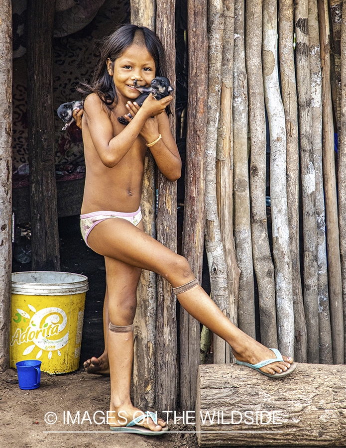 Native child with puppy in Amazon jungle in Venezuela.