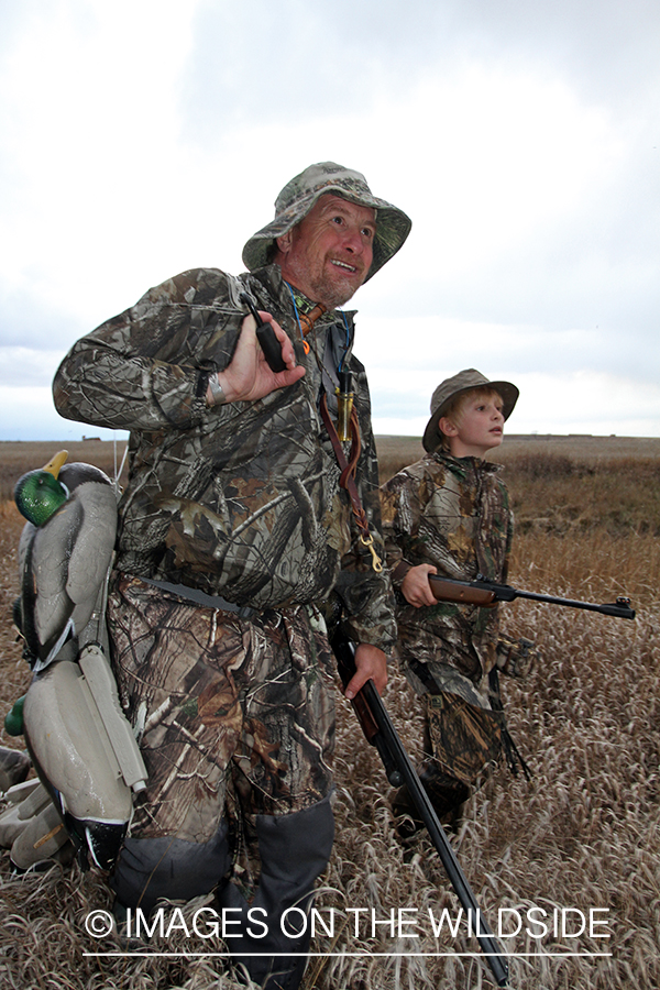 Father and son waterfowl hunters with bagged waterfowl.