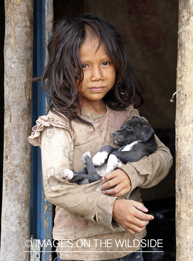 Native child with puppy in Amazon jungle in Venezuela.