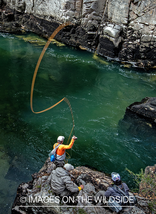 Flyfisherman casting to stream in canyon.