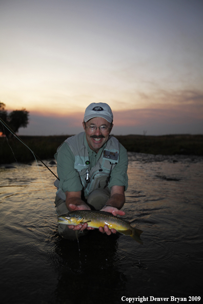 Flyfisherman with brown trout