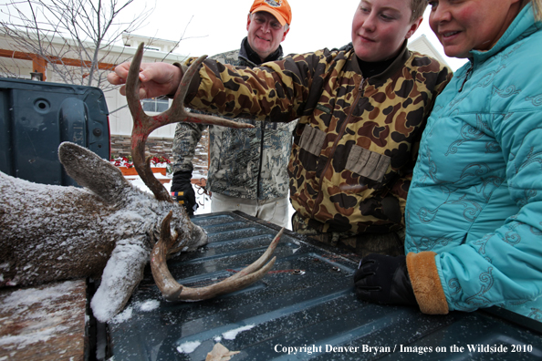 Son shows off his downed white-tail buck to mother