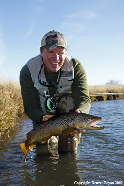 Flyfisherman with large male brown trout.