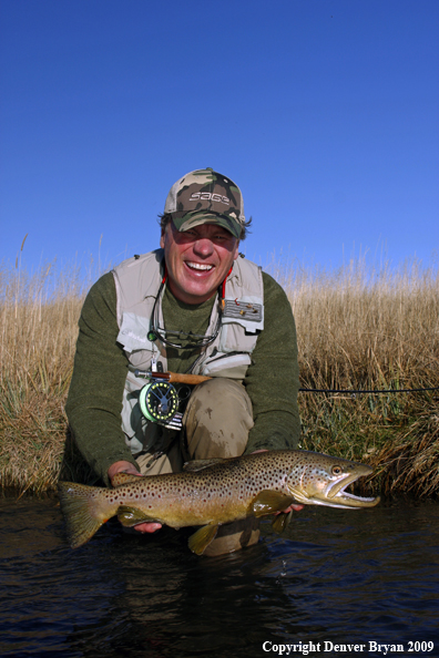 Flyfisherman with large male brown trout.