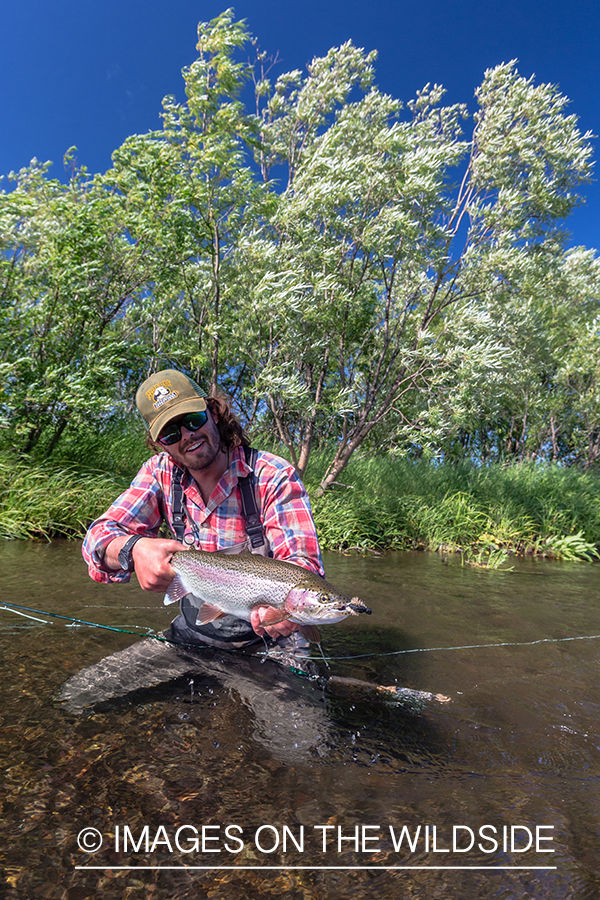 Flyfisherman with rainbow trout in Sedanka river in Kamchatka Peninsula, Russia.