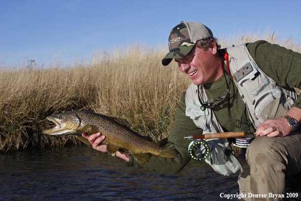 Flyfisherman with large male brown trout.