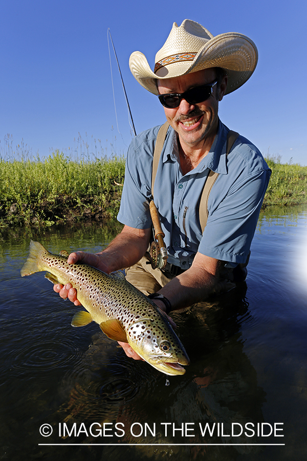 Flyfisherman with brown trout. 