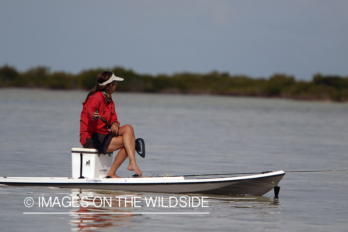 Saltwater flyfishing woman on stand up paddle board.