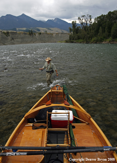 Flyfisherman with drift boat in forefront.