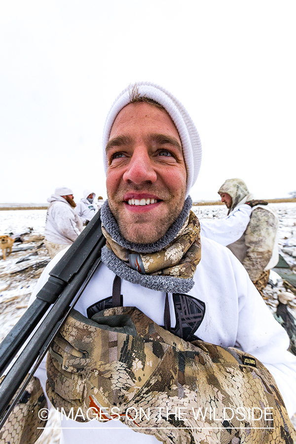 Hunters in field with decoys. 