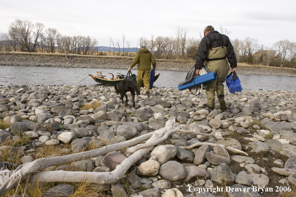 Flyfishermen walking to boat on river.