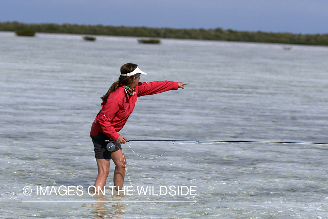 Saltwater flyfishing woman pointing at fish.