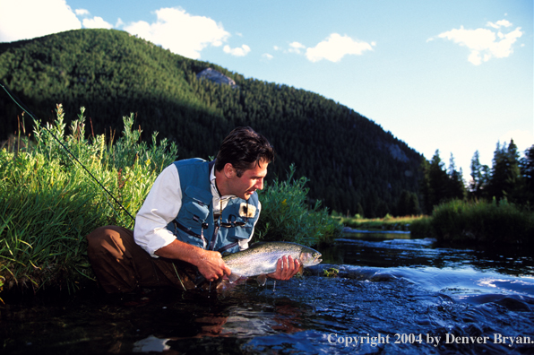 Flyfisherman holding brown trout.