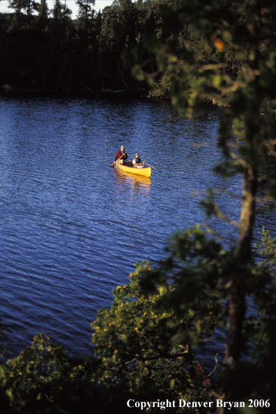 Father and son fishing from cedar canoe.