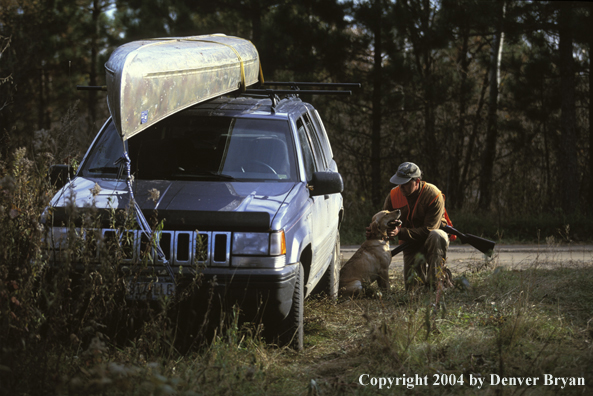 Upland bird hunter with yellow Labrador Retriever.