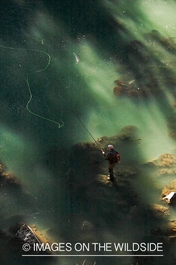 Flyfisherman casting on river. 