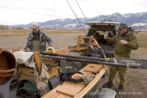 Flyfishermen rigging up driftboat and rods to fish. 