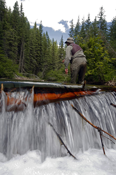 Flyfisherman standing above waterfall flyfishing