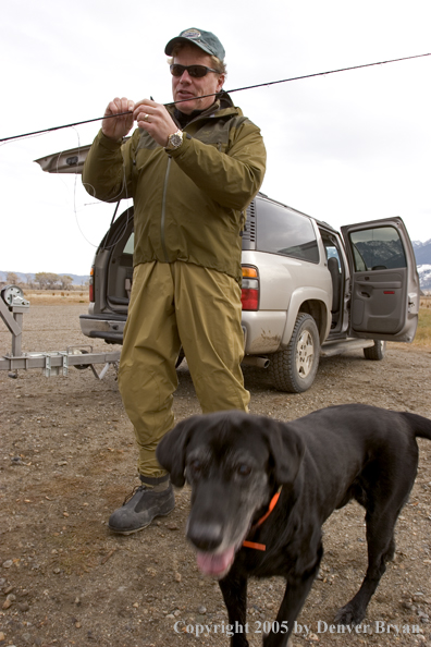 Flyfishermen rigging up driftboat and rods to fish. 