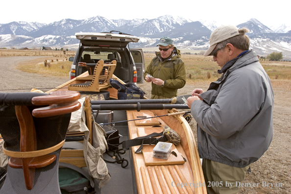 Flyfishermen rigging up driftboat and rods to fish. 