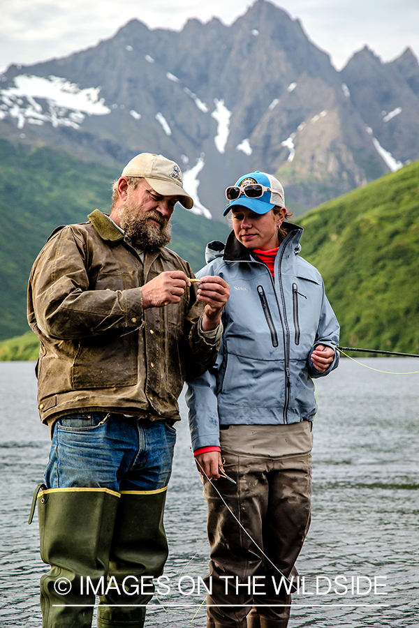 Flyfishermen tying fly on line.