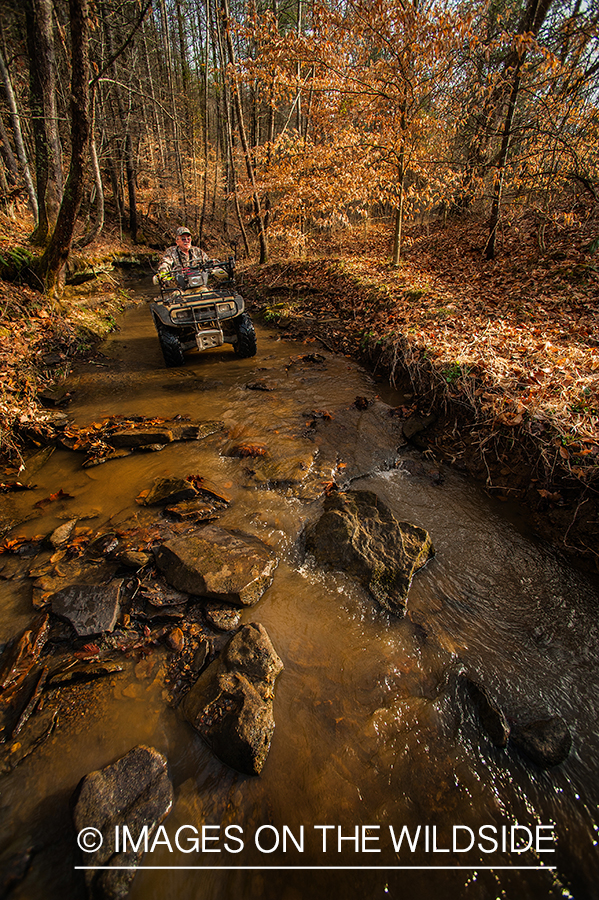 Bowhunter on ATV in field. 