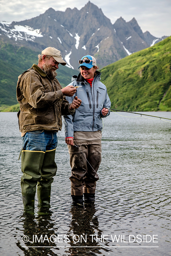 Flyfishermen tying fly on line.