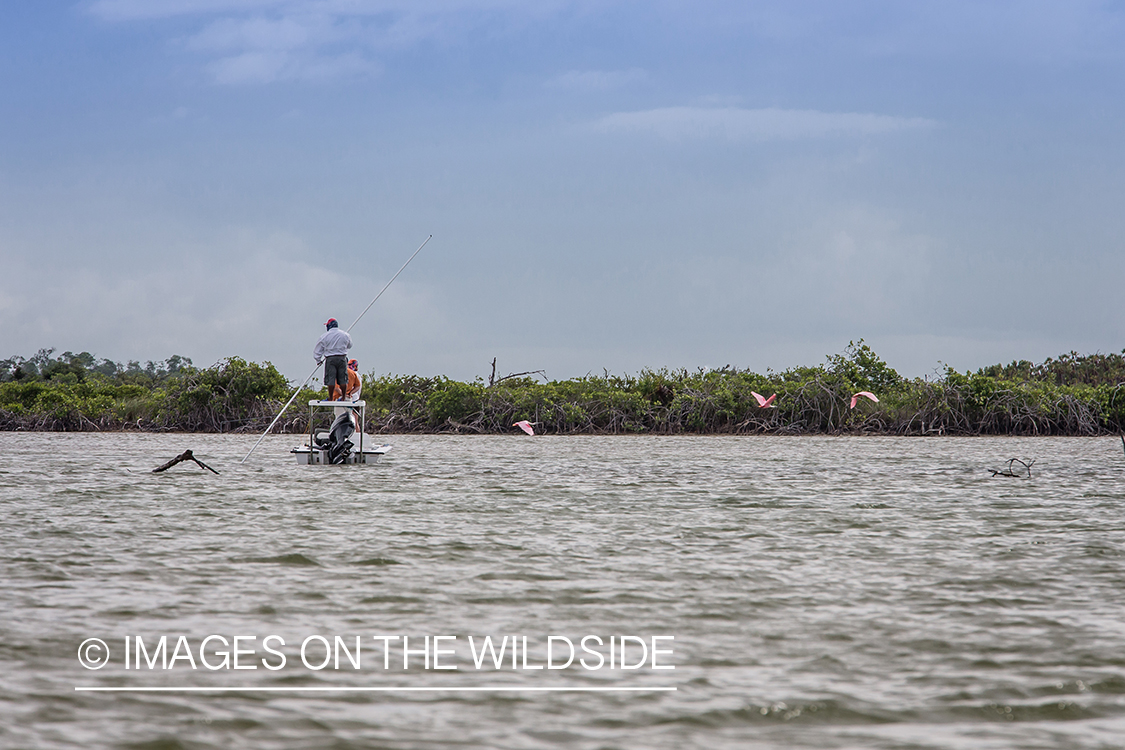 Flyfisherman with fishing guide on flats boat.