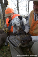 Upland bird hunters in field with dog and bagged birds.