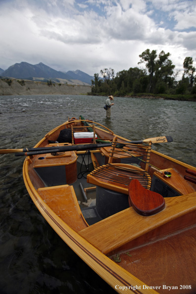 Flyfisherman with drift boat in forefront.