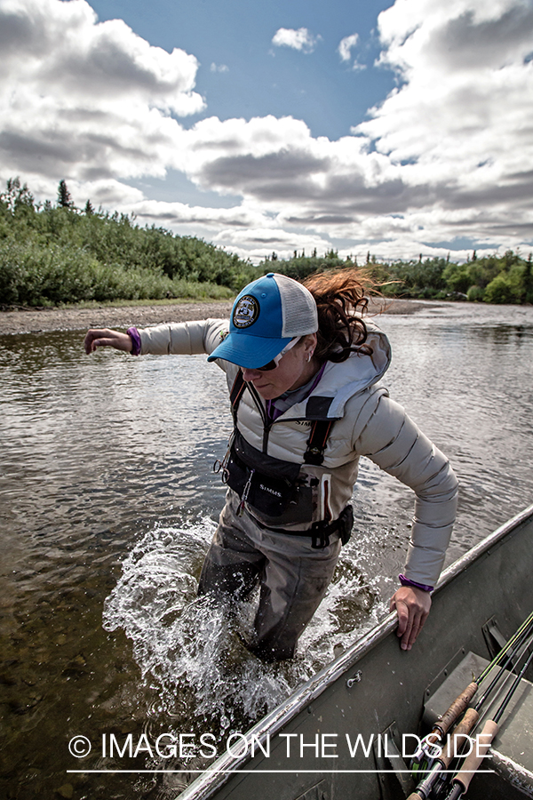 Flyfisherman jumping out of boat.