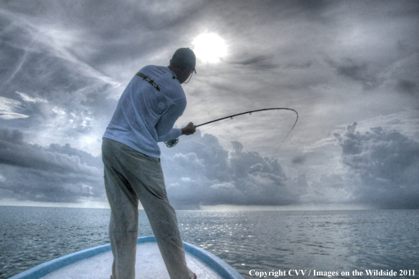 Flyfisherman on boat with fish on. 