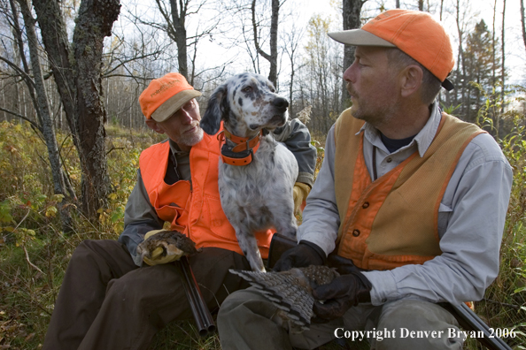 Upland bird hunters in field with dog and bagged birds.