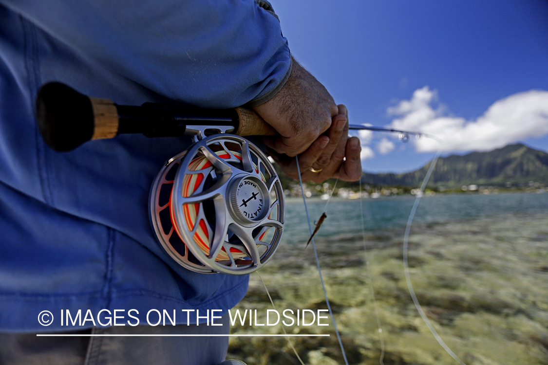 Saltwater flyfisherman fishing on flats boat, in Hawaii. 